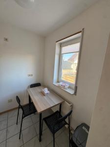 a small room with a table and chairs and a window at City Apart am MUSEUM nahe BADEWELT in Sinsheim