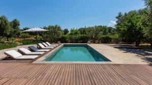 una piscina con tumbonas y sombrilla en BALiPALAZEVILLA, en Tanah Lot 6 fotos más