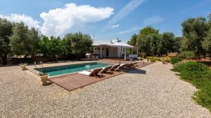 Una piscina con tumbonas y una casa. en BALiPALAZEVILLA, en Tanah Lot