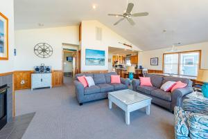 ein Wohnzimmer mit zwei Sofas und einem Tisch in der Unterkunft K1052 The Blue Heron - Pool, Hot Tub, Ocean Views, Close to Oregon Inlet in Grun Island