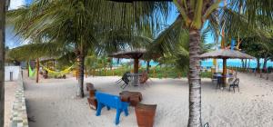 a beach with tables and chairs and palm trees at Fonte dos Corais - Suíte Lua na Praia in Maragogi +27 photos