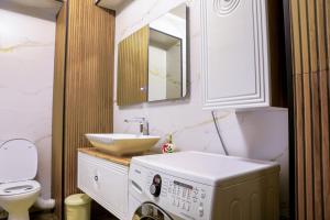 Un baño con lavabo y lavadora. en Elegant Central Stay - Targul de Craciun Craiova, en Craiova 24 fotos más
