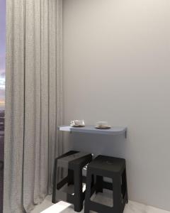 ein weißes Zimmer mit einem Tisch und 2 Stühlen in der Unterkunft Pousada Mar do Sul in Itapema