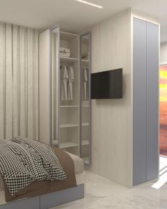 ein Schlafzimmer mit einem Schrank, einem TV und einem Bett in der Unterkunft Pousada Mar do Sul in Itapema