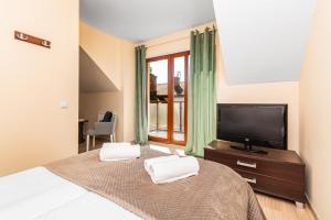 - une chambre avec un lit et une télévision à écran plat dans l'établissement P20 apartament, à Sztutowo