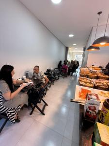 een groep mensen die aan tafels in een restaurant zitten bij Pousada Maranata in Aparecida +7 foto's