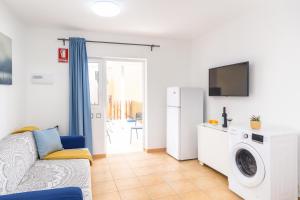 een woonkamer met een bank en een koelkast bij Green Holiday Island in Maspalomas