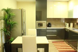 eine Küche mit Tisch und Stühlen und einem Kühlschrank in der Unterkunft Ferienhaus mit Privatpool für 6 Personen ca 290 m in Paradela, Regio Norte Minho in Paradela