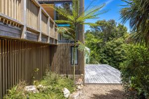 an external view of a house with a wooden fence at Birdsong Sanctuary - Be My Guest Waiheke in Waiheke Island