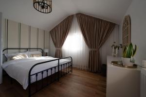 a bedroom with a bed and a window with curtains at Origini de Rucar in Rucăr