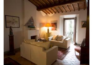 un salon avec deux canapés blancs et une cheminée dans l'établissement Hochwertige Wohnung Im Turm Schlösschen, à Montemerano