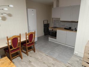a kitchen with white cabinets and a table and chairs at Myklebostad in Steigen