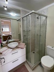 ein Badezimmer mit Dusche, Waschbecken und Toilette in der Unterkunft Apartamento Cond JK Parque Club in Pelotas