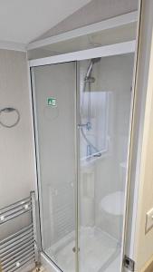 a shower in a bathroom with a glass door at Sunrise Holidays Skegness - Pearl in Skegness