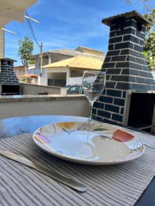 ein Teller mit einem Glas Wein auf einem Tisch in der Unterkunft Casinhas da toca in Búzios + 47 Fotos