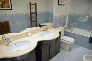 un bagno con due lavandini e un WC di Villa La Perla De Sonabia a Oriñón Altre 37 foto
