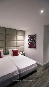 una camera da letto con un letto grande e un dipinto sul muro di Hotel Donia Sfax a Sfax