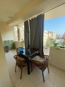 einen Balkon mit einem Tisch, 2 Stühlen und einem Fenster in der Unterkunft Florenza Khamsin Resort in Hurghada