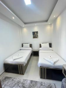 zwei Betten in einem Zimmer mit weißen Wänden in der Unterkunft Florenza Khamsin Resort in Hurghada