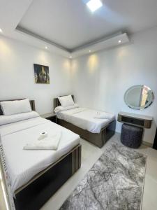 ein Hotelzimmer mit zwei Betten und einem Spiegel in der Unterkunft Florenza Khamsin Resort in Hurghada