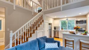 ein Wohnzimmer mit einem blauen Sofa und einer Treppe in der Unterkunft Cozy Cannon Beach Home Near Haystack Rock Downtown Steps from the Sea by AvantStay in Cannon Beach