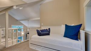 ein kleines Zimmer mit einem Bett mit blauen Kissen in der Unterkunft Cozy Cannon Beach Home Near Haystack Rock Downtown Steps from the Sea by AvantStay in Cannon Beach