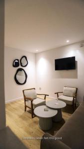 un soggiorno con due sedie e due tavoli di Hotel Donia Sfax a Sfax