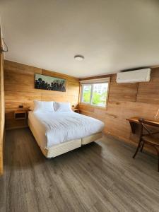 ein Schlafzimmer mit Bett, Schreibtisch und Fenster in der Unterkunft suites puerto varas camino al corazon in Puerto Varas + 19 Fotos