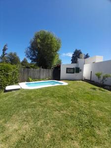 a backyard with a swimming pool in the grass at Casa el sueño de Alicia in Villa del Dique