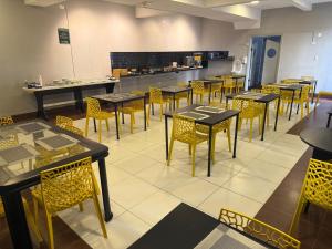 a restaurant with tables and chairs and a kitchen at Unity Hotel - Santos in Santos