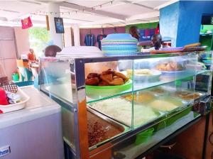 eine Vitrine in einer Küche mit Lebensmitteln in der Unterkunft Giriama Village Lounge in Mombasa
