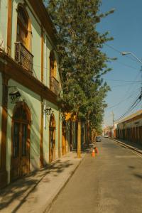 an empty street with a tree and a building at Hotel HALLEY & Vive la Magia del Valle de Elqui in Vicuña