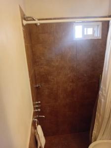 une salle de bain avec douche, toilettes et fenêtre dans l'établissement Cafayate Suite, à Cafayate