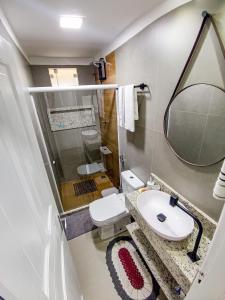 un bagno con un water, un lavandino e uno specchio di Casa 1178 a Santa Teresa