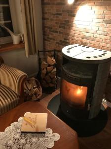 une cheminée dans un salon avec un livre sur une table dans l'établissement Gemütliches Reetdachhaus In Schleswig Holstein, à Neuendorf-Sachsenbande 14 autres photos