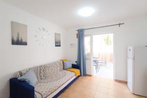 een woonkamer met een bank en een koelkast bij Green Holiday Island in Maspalomas