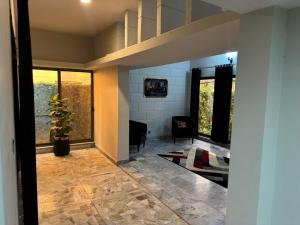 a living room with a large window and a plant at Amberwood residency in Islamabad