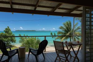 a table and chairs on a porch with a view of the ocean at Studio with a view of a heavenly lagoon in Bora Bora