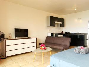 a living room with a couch and a television at Studio with a view of a heavenly lagoon in Bora Bora