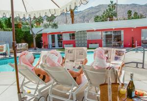 a couple of people sitting in chairs by a pool at The Muse Hotel Palm Springs in Palm Springs