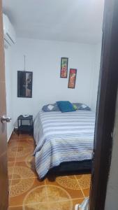 une chambre avec un lit dans une pièce blanche dans l'établissement Apartamento a unos pasos de la playa, à Carthagène des Indes