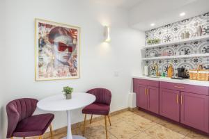 a kitchen with purple cabinets and a white table and chairs at The Muse Hotel Palm Springs in Palm Springs