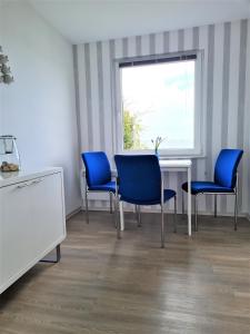 ein Wartezimmer mit blauen Stühlen und einem Tisch in der Unterkunft Fh Rügenblick in Stralsund