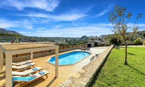une piscine avec des chaises longues et une maison dans l'établissement Ferienhaus Für 16 Personen In Episkopi, Kreta West Kreta, à Episkopi