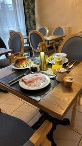 a wooden table with plates of food on it at Hôtel Blue Garden in Grandvillers