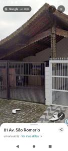 大普拉亚Casa pé na areia 40 metros da praia Caiçara的一座带门和栅栏的房子