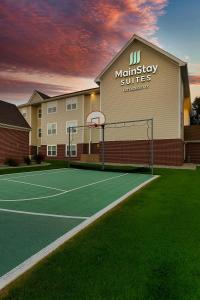 a tennis court in front of a building at MainStay Suites Appleton Airport - Fox River Mall Area in Appleton
