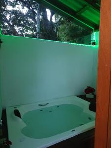 a bath tub in a room with a window at Residencial Rodrigues Florianópolis in Florianópolis