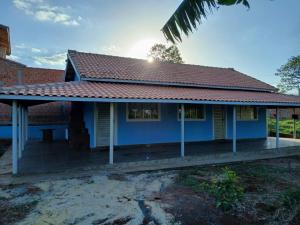 a blue house with a red roof at Chácara pedacinho do paraíso in Cesário Lange
