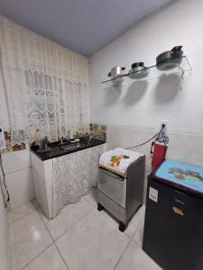 une petite cuisine avec un évier et une cuisinière dans l'établissement Condominio Merces, à Belo Horizonte